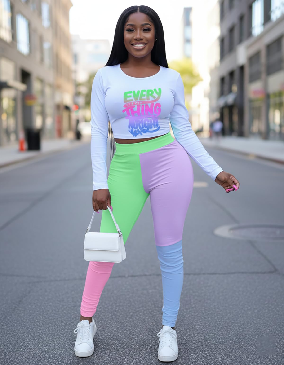 Woman in colorful outfit with text on shirt walking on a city street.
