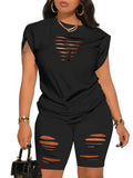 Black distressed outfit with matching top and shorts on a model against a white background