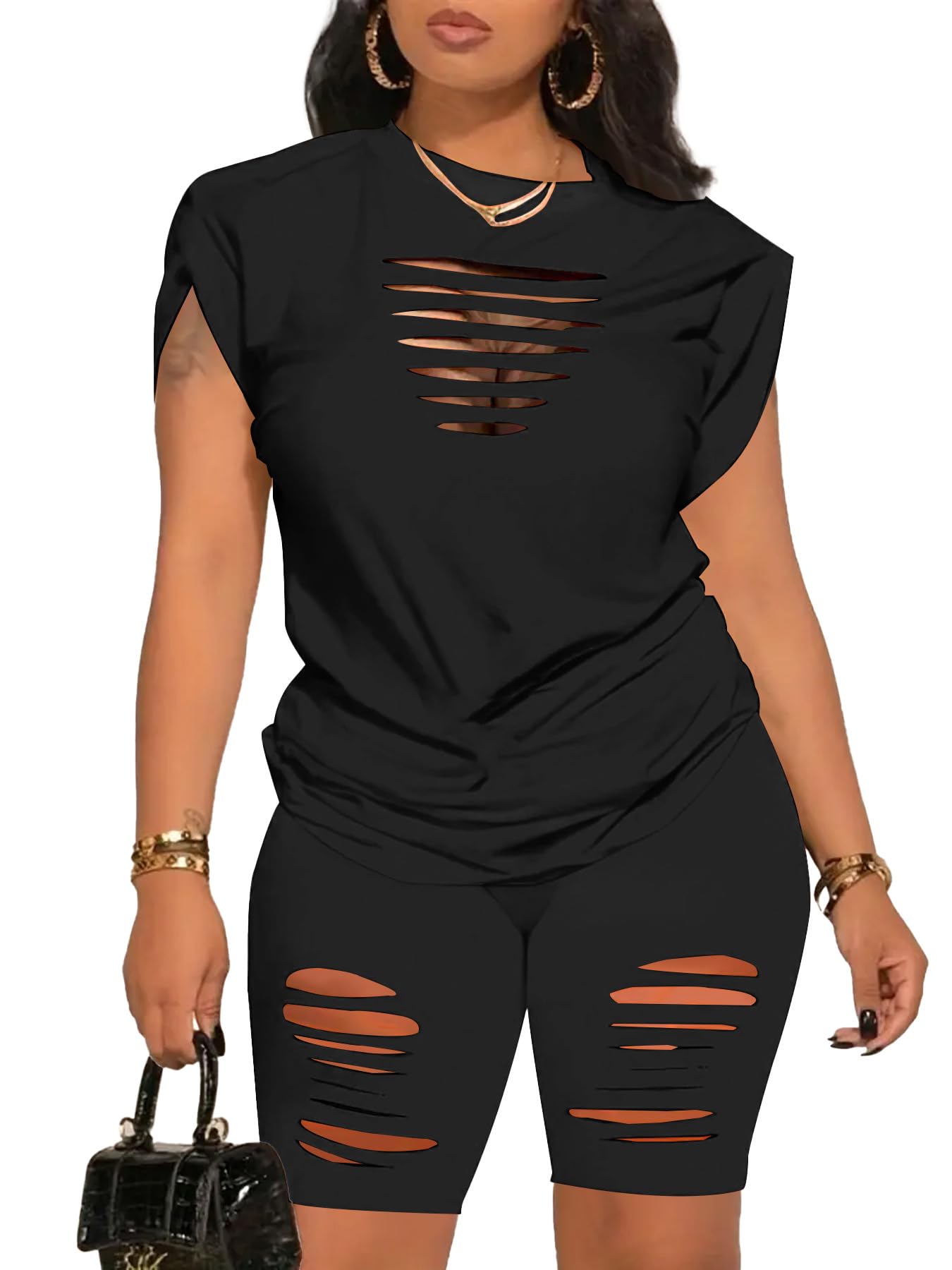 Black distressed outfit with matching top and shorts on a model against a white background