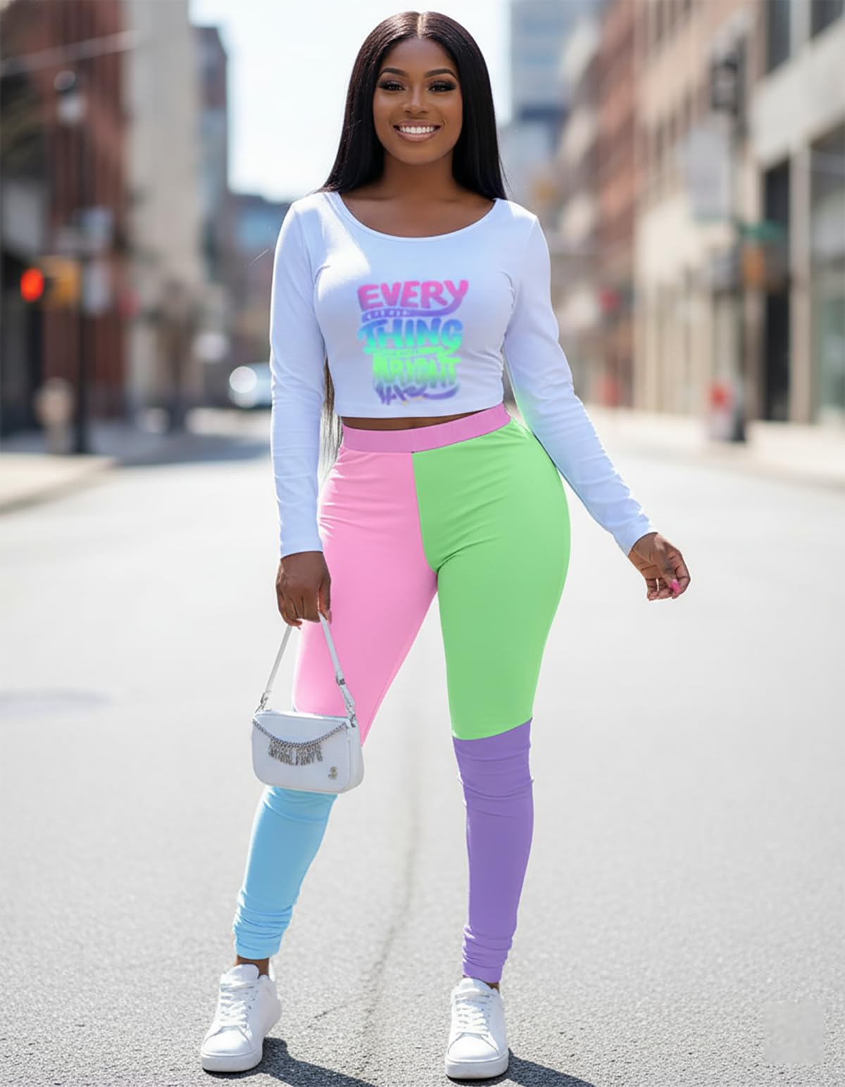 Woman wearing a colorful outfit with a white long-sleeve shirt and multicolored pants on a city street.