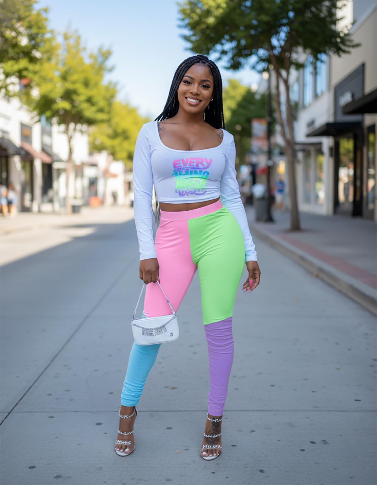 Woman in colorful pants and a white crop top on a city street.